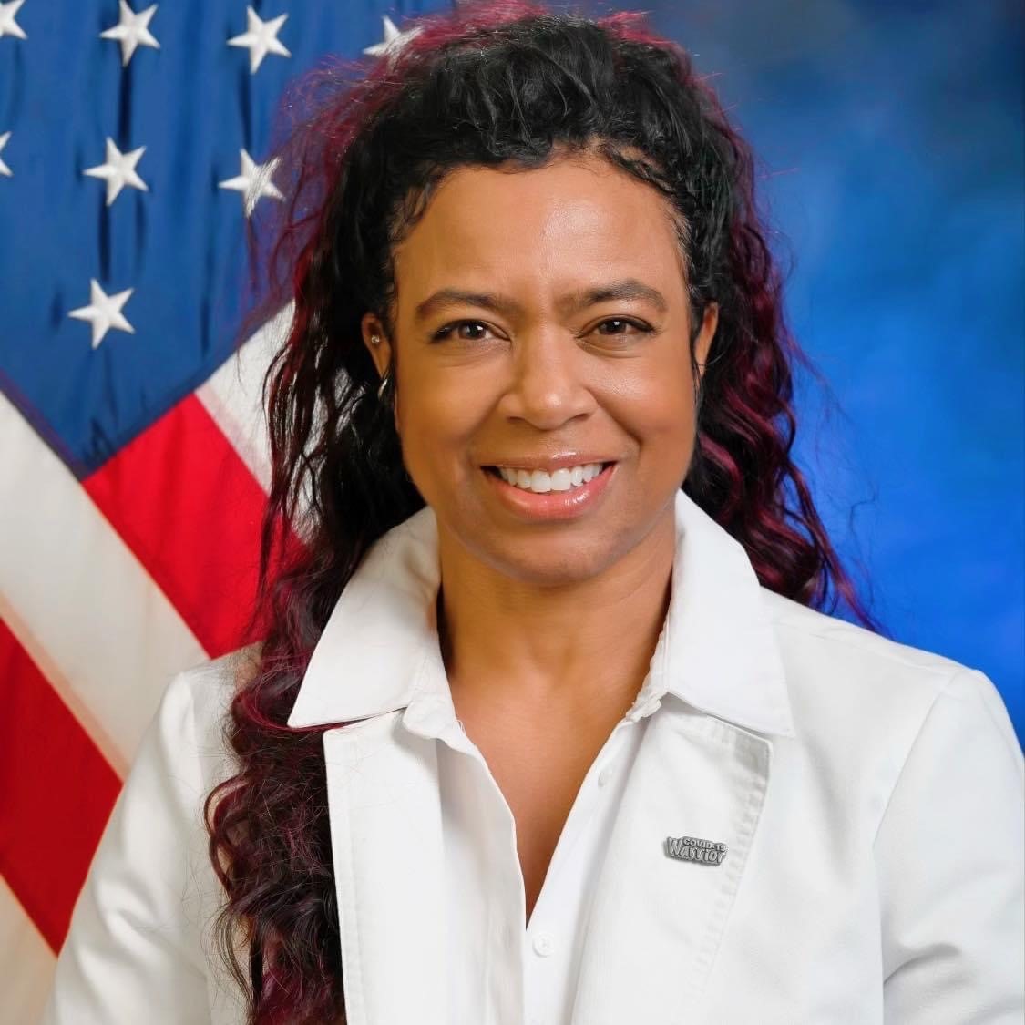 head shot in front of American Flag